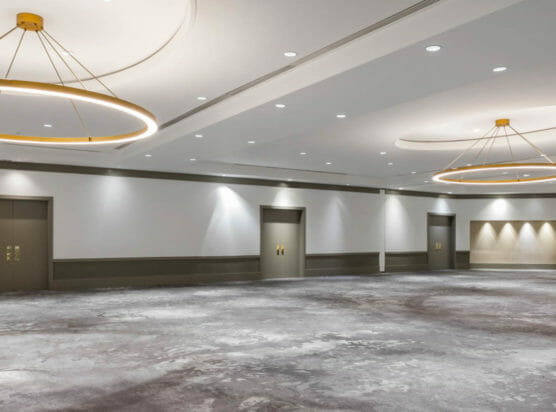 Empty Jordan ballroom with circular chandeliers and gray carpeted floor