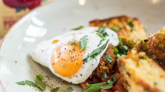 Close up of lightly fried egg served on top of biscuits