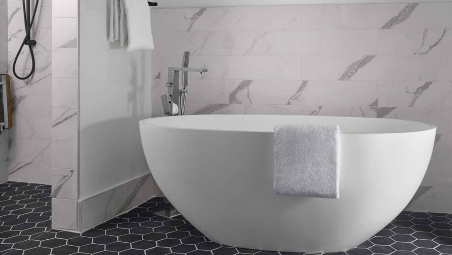 White luxurious bathtub with towel draped over the side