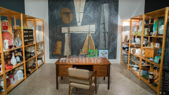 Shop shelves with decorative nicknacks for your home with desk in between with various sized glassware