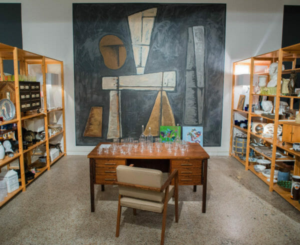 Shop shelves with decorative nicknacks for your home with desk in between with various sized glassware