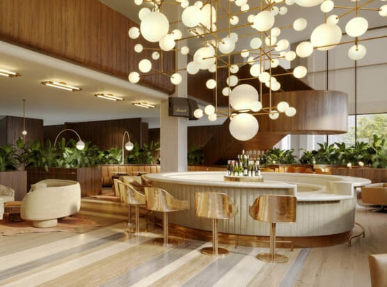 Circular bar encircled with gold bar stools and has spherical ceiling lamps