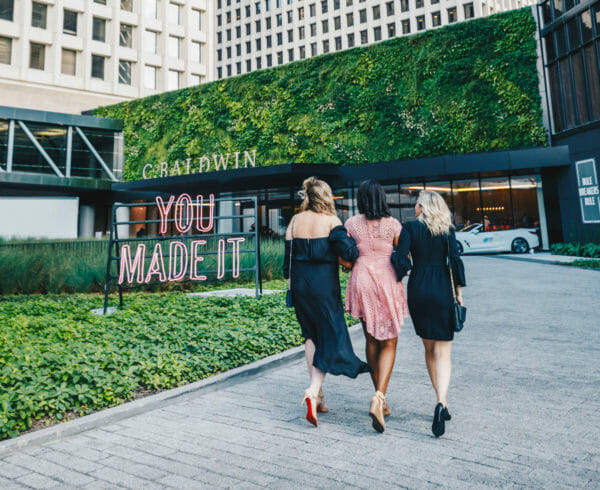 Three women walking towards C. Baldwin Hotel