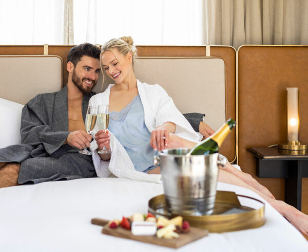 A couple enjoying a romantic meal in bed.