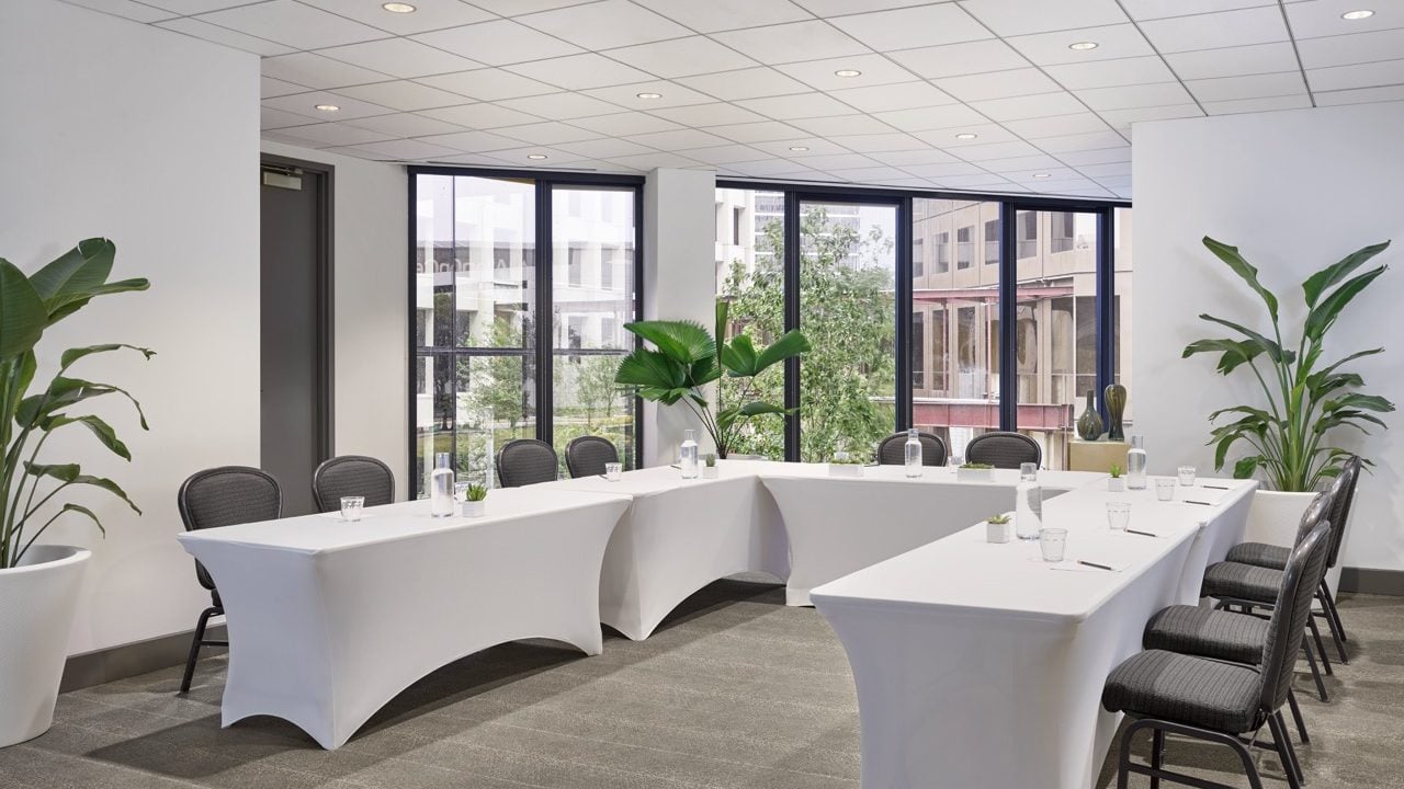 The I. Wilson meeting room at the C. Baldwin Hotel. The bright room has its tables set up in a U-shape for a professional event.